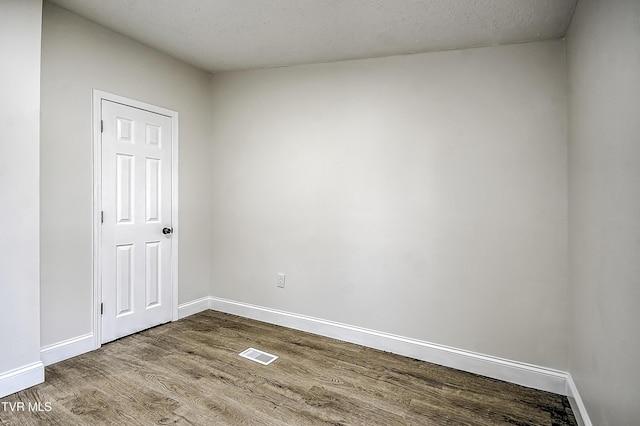 spare room featuring a textured ceiling and hardwood / wood-style floors