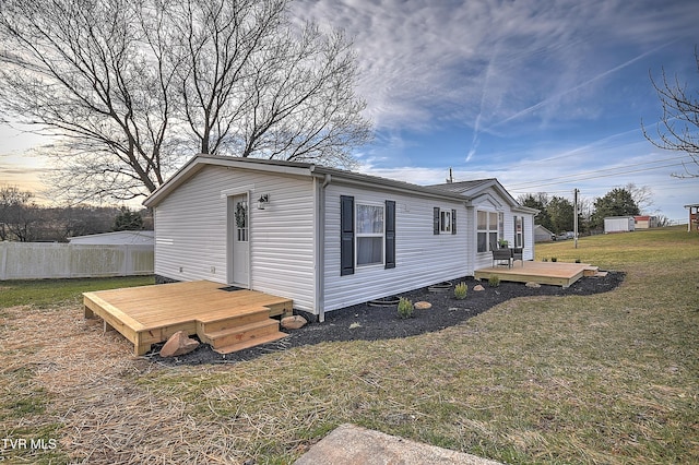 view of home's exterior featuring a deck and a yard