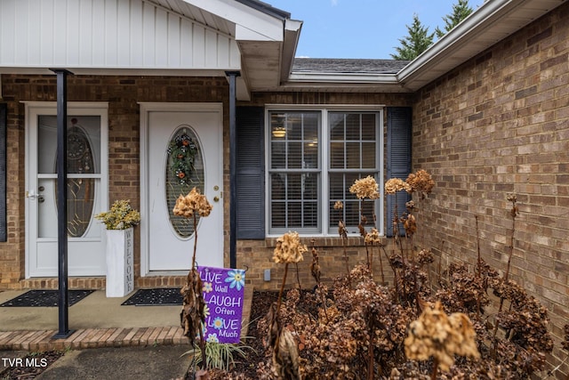 view of exterior entry with brick siding