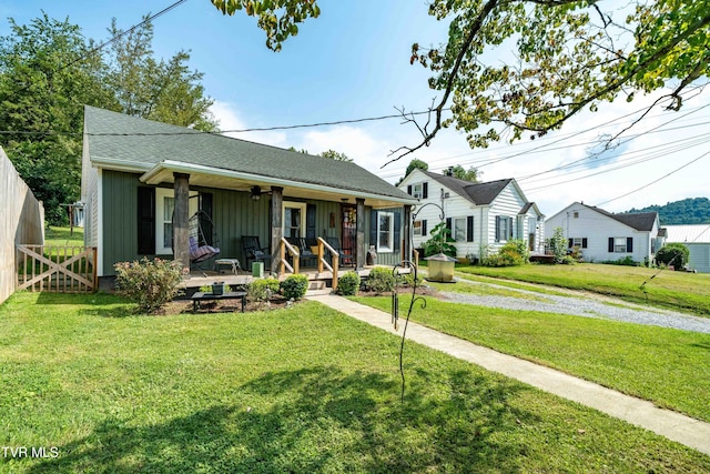 view of front of house with covered porch, fence, a front lawn, and board and batten siding