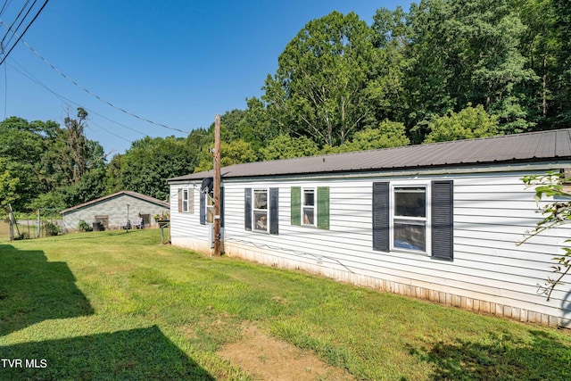 view of home's exterior featuring metal roof and a lawn