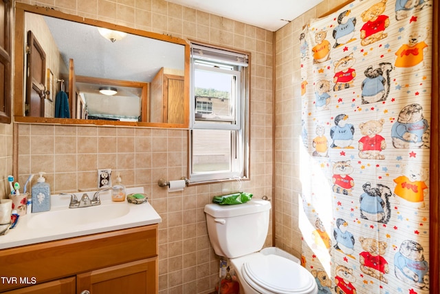 full bath featuring vanity, toilet, and tile walls