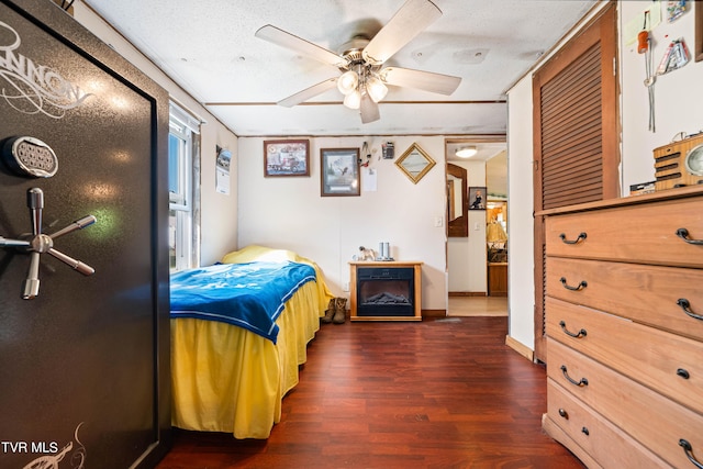 bedroom with baseboards, a ceiling fan, and dark wood finished floors