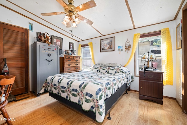 bedroom with light wood-style flooring, baseboards, ornamental molding, lofted ceiling, and ceiling fan