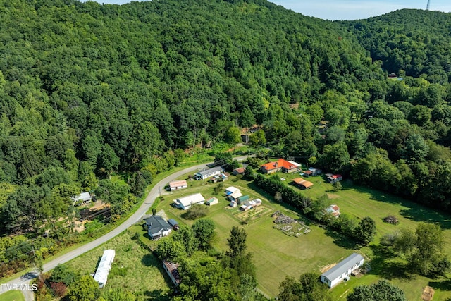 birds eye view of property featuring a forest view