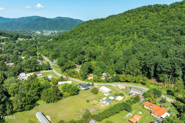 aerial view featuring a wooded view and a mountain view