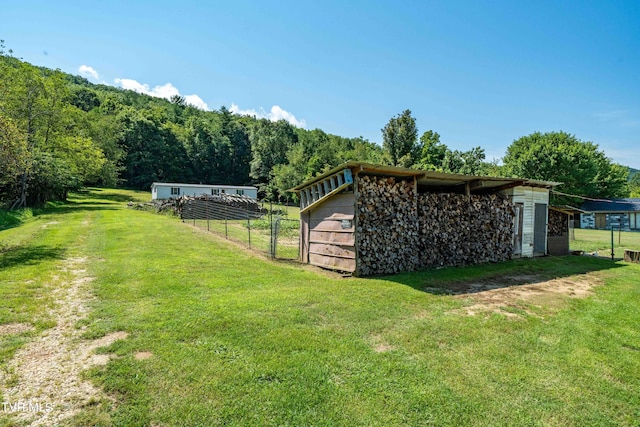 view of yard with an outdoor structure and fence