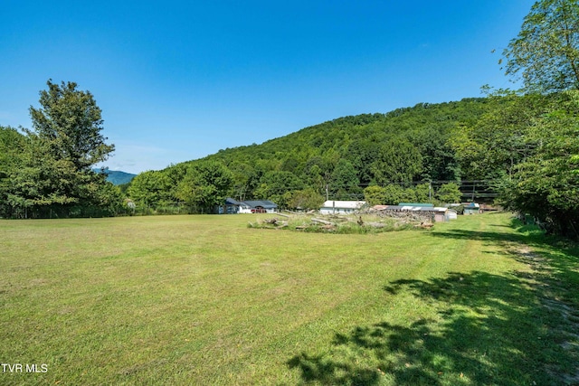 exterior space featuring a wooded view and a rural view