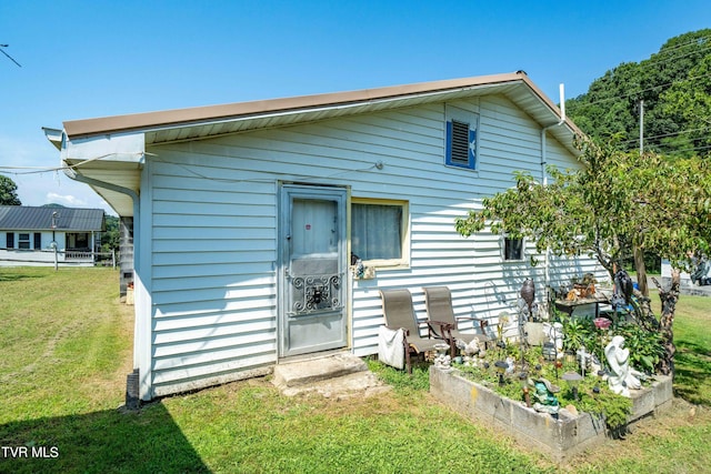 rear view of house with a lawn and a garden