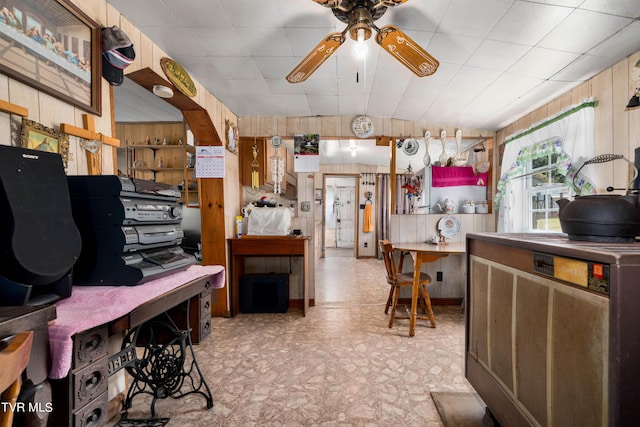 kitchen featuring ceiling fan, lofted ceiling, and wooden walls