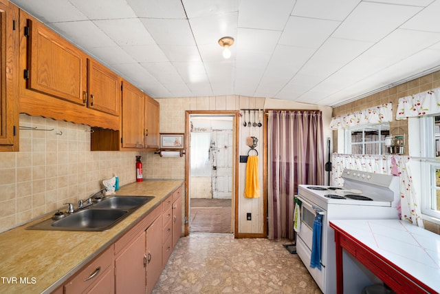 kitchen with a sink, white electric stove, brown cabinetry, and decorative backsplash