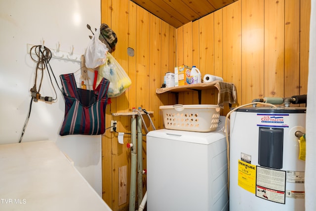 washroom featuring laundry area, washer / dryer, wooden walls, and electric water heater