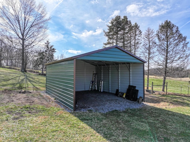 view of pole building with a carport, driveway, and fence