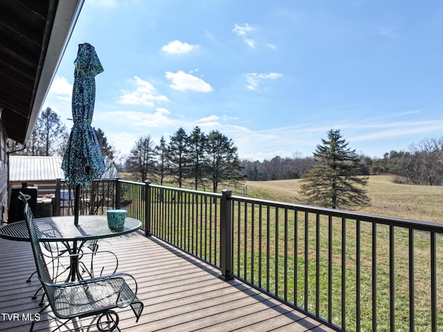 wooden deck featuring outdoor dining area and a lawn