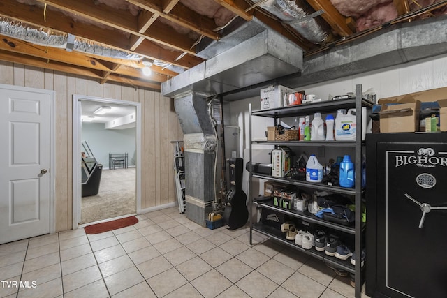 unfinished basement featuring wood walls and tile patterned floors