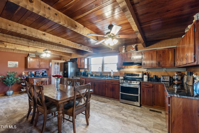 kitchen with stainless steel appliances, dark countertops, under cabinet range hood, and a ceiling fan