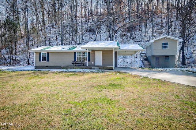 view of front of home featuring driveway, metal roof, an attached carport, crawl space, and a front yard