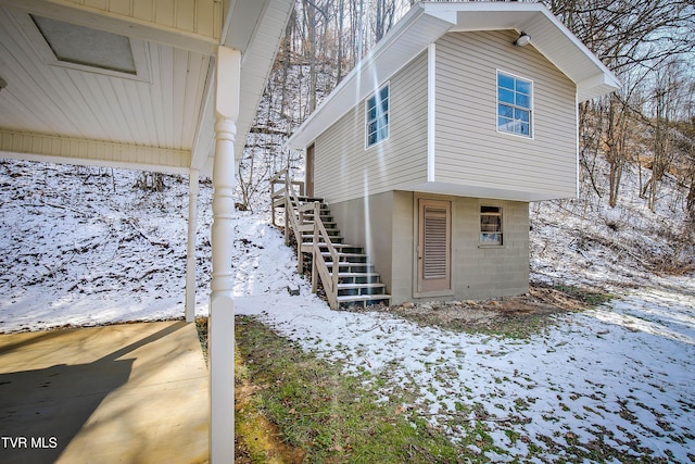 view of snowy exterior with stairs