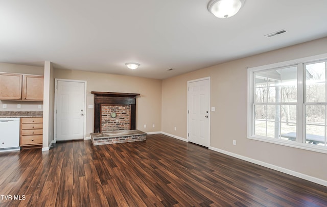 unfurnished living room featuring visible vents, baseboards, and dark wood finished floors