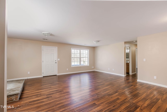 spare room featuring dark wood finished floors and baseboards