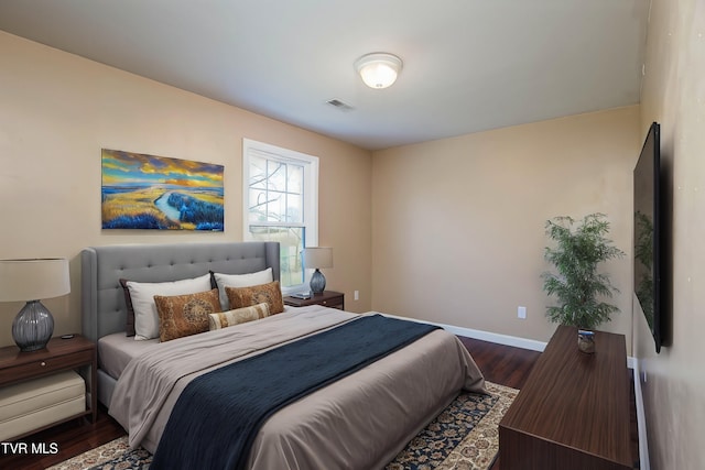 bedroom with dark wood-style flooring, visible vents, and baseboards