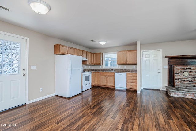 kitchen featuring dark wood-style flooring, visible vents, a sink, white appliances, and baseboards