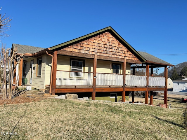 view of front of property with a front lawn and a shingled roof