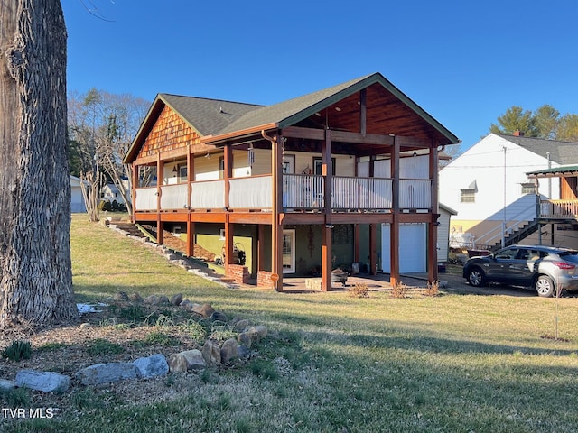 rear view of house with a garage, a lawn, and a wooden deck