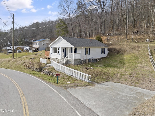 view of front of house featuring central air condition unit and roof with shingles