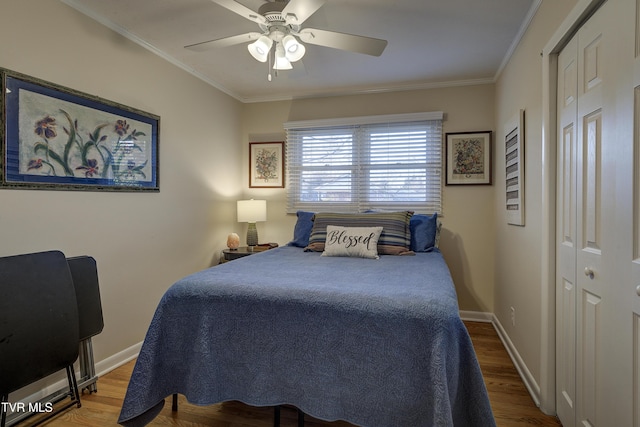 bedroom with ornamental molding, ceiling fan, baseboards, and wood finished floors