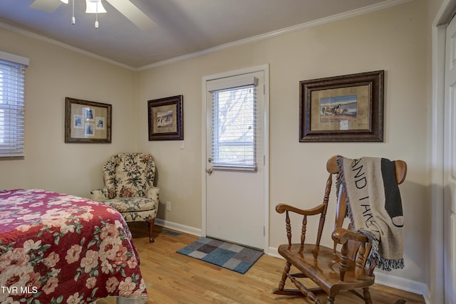 bedroom with ornamental molding, light wood-type flooring, baseboards, and a ceiling fan