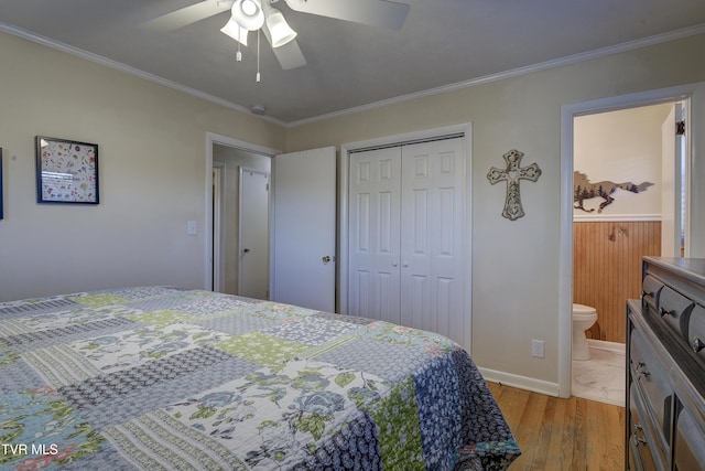 bedroom with light wood finished floors, baseboards, connected bathroom, ornamental molding, and a closet