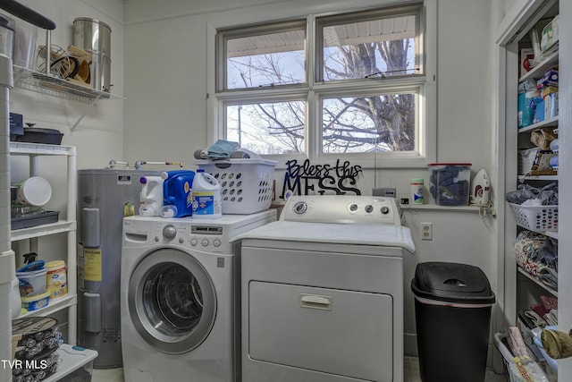 laundry area featuring laundry area, electric water heater, and washing machine and clothes dryer