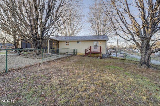 back of house featuring metal roof, crawl space, fence, and a sunroom