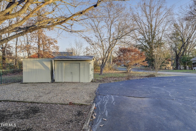 exterior space with a storage unit, an outdoor structure, and fence