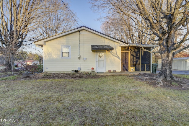 view of front of home with a sunroom and a front lawn