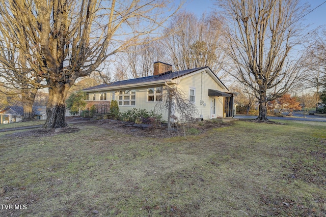 view of front of property featuring a front lawn and a chimney