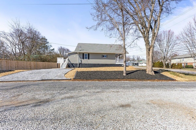 view of front of house with driveway, stairway, and fence