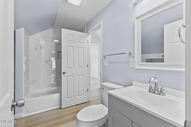 full bath featuring a textured ceiling, shower / tub combination, toilet, wood finished floors, and vanity