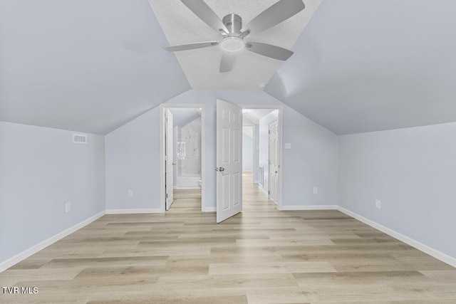 additional living space with lofted ceiling, light wood-style flooring, visible vents, and baseboards