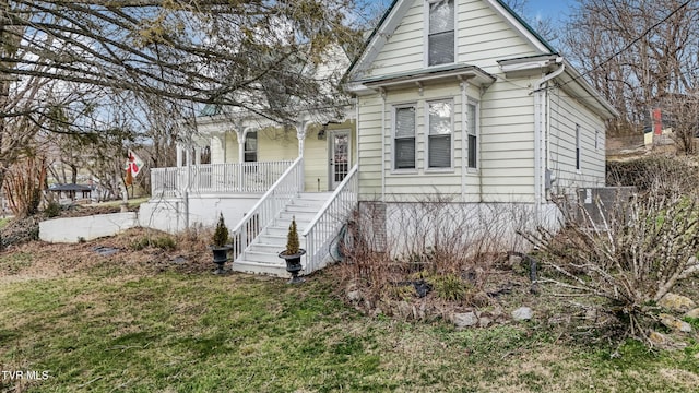 view of front of house featuring a porch, stairway, and a front lawn