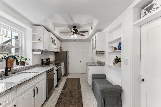 kitchen featuring a sink, white cabinets, appliances with stainless steel finishes, open shelves, and a tray ceiling