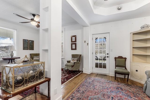 sitting room with baseboards, a ceiling fan, wood finished floors, and ornamental molding