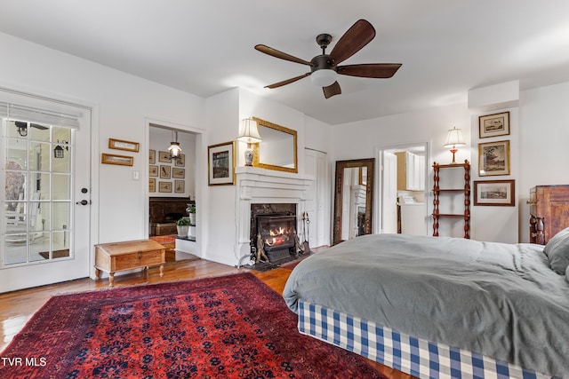 bedroom with a premium fireplace and wood finished floors