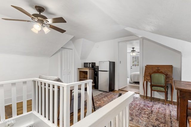 bonus room with light wood-style floors and vaulted ceiling