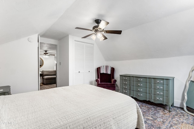 bedroom featuring lofted ceiling, ceiling fan, dark carpet, and a closet