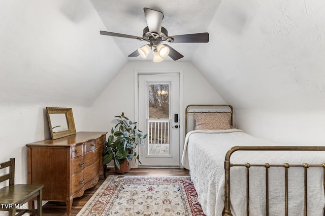 bedroom featuring access to exterior, a ceiling fan, vaulted ceiling, and wood finished floors