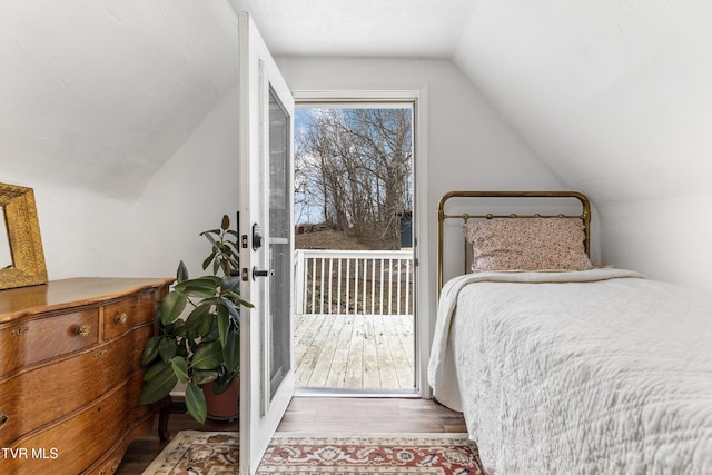 bedroom with vaulted ceiling and wood finished floors