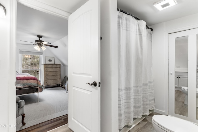 ensuite bathroom with ceiling fan, toilet, wood finished floors, visible vents, and ensuite bath