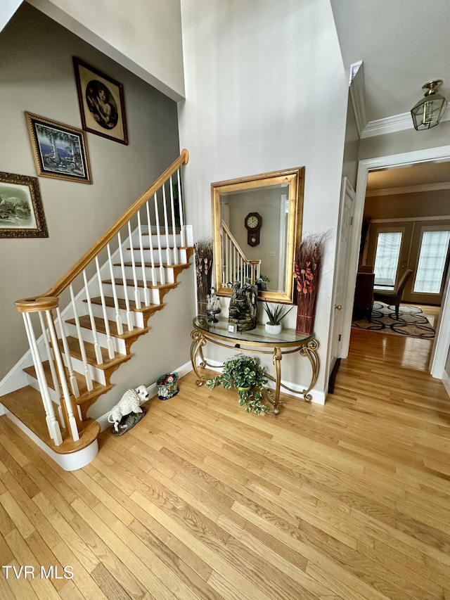 interior space featuring stairs, ornamental molding, and wood finished floors